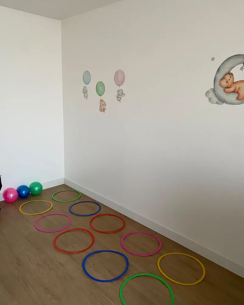 Salle d'éveil avec cerceaux colorés et ballons